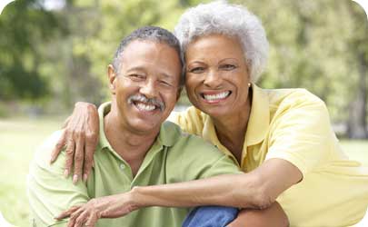 senior married couple smiling, cuddling and facing camera