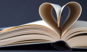 Book with pages folded into a love heart shape to represent research for the history